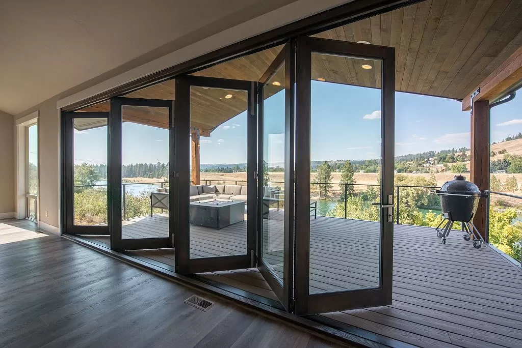 Folding glass doors opening to a deck with river view