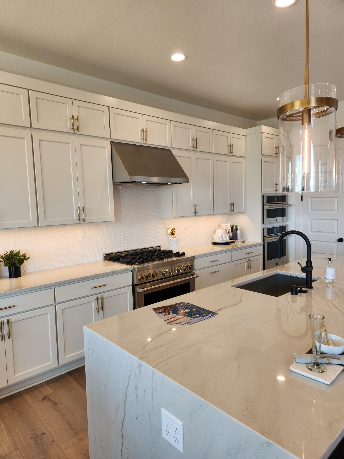 Gourmet kitchen with marble waterfall island and brass hardware